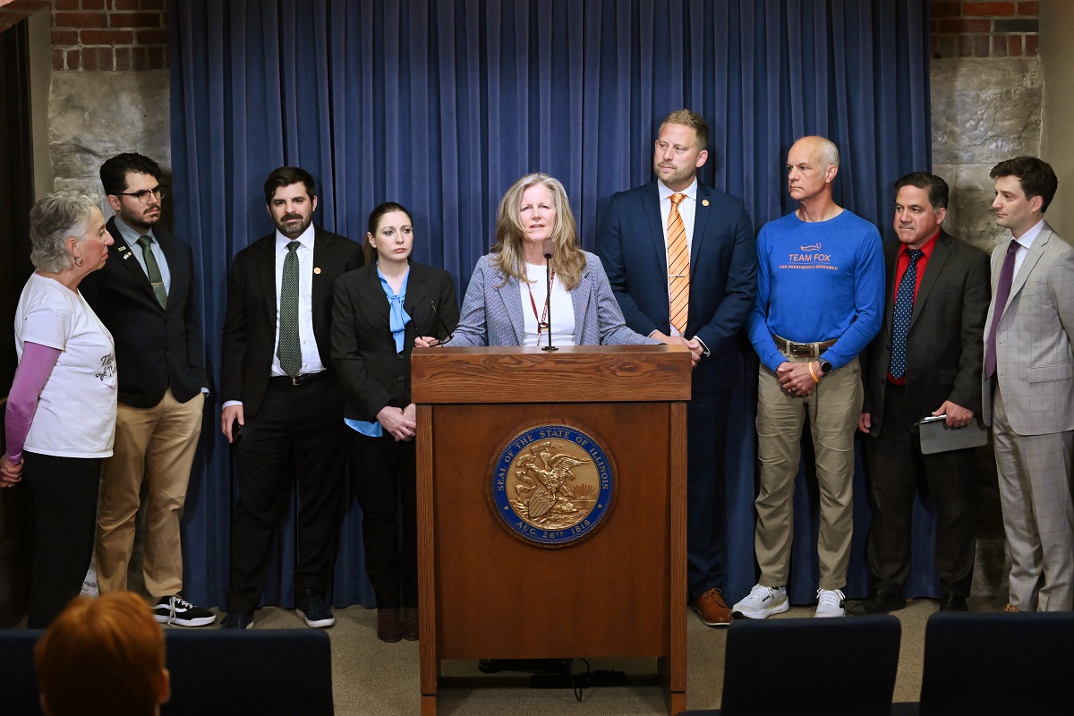 State Senator Laura Ellman speaking at a press conference prior to the subject matter hearing on Senate Bill 3161 alongside advocates; Grant Niver, Senior State Government Relations Manager from the Michael J. Fox Foundation; State Senator Rachel Ventura; and Richard Cole Eastman, Attorney/Lobbyist/Parkinson's Advocate