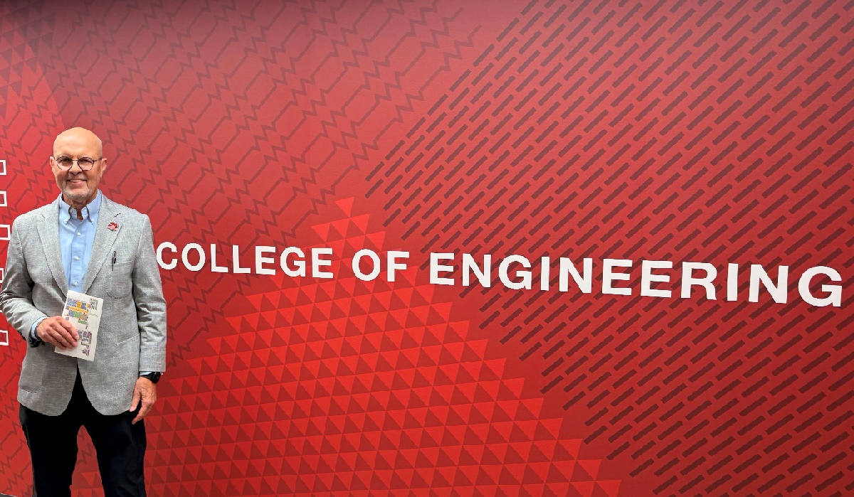 State Senator Dave Koehler stands next to text that says "College of Engineering" at Illinois State University's new College of Engineering facility