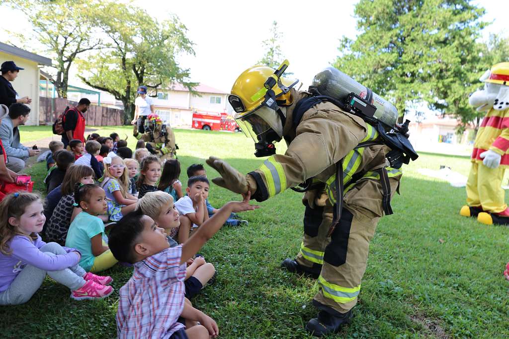 Firefighter greets kids on lawn